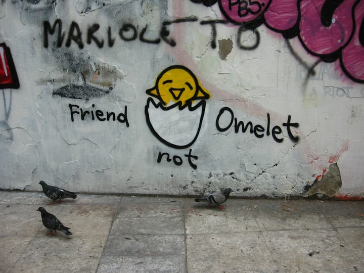 A graffiti picture of an egg with a chick poking its head out. Text says: "Friend not omelet [sic]".